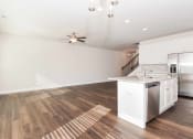Thumbnail 34 of 60 - a kitchen and living room with a staircase in the background