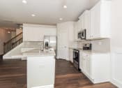 Thumbnail 42 of 60 - a kitchen with white cabinets and a large island