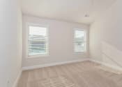Thumbnail 43 of 60 - a bedroom with two windows and a carpeted floor