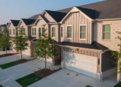 Thumbnail 27 of 60 - a house with a garage and trees in front of it