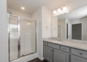 Thumbnail 47 of 60 - a bathroom with gray cabinets and granite countertops