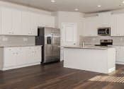 Thumbnail 36 of 60 - a kitchen with white cabinets and a stainless steel refrigerator