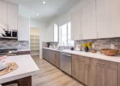 Thumbnail 34 of 47 - a large kitchen with wooden cabinets and white counter tops
