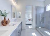 Thumbnail 44 of 47 - a white bathroom with a shower and two sinks