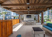 Thumbnail 27 of 31 - a patio with a table and chairs under a wooden roof