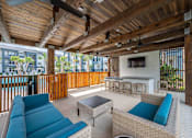 Thumbnail 26 of 31 - a patio with couches and a table and a tv
