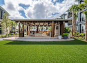 Thumbnail 25 of 31 - a covered patio with a lawn in front of some apartments