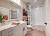 Thumbnail 7 of 31 - a bathroom with a shower and a sink and a toilet