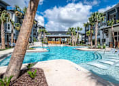 Thumbnail 29 of 31 - a large swimming pool with palm trees and apartments in the background