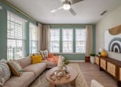 Thumbnail 11 of 31 - furnished living room with large windows and a ceiling fan