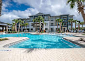 Thumbnail 31 of 31 - a large swimming pool with an apartment building in the background