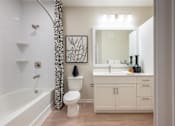 Thumbnail 17 of 31 - a white bathroom with a shower curtain and a toilet and a sink