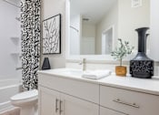 Thumbnail 16 of 31 - a bathroom with a large mirror and a toilet and a sink