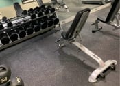 Thumbnail 19 of 32 - a gym with weights and a tv in the wall