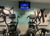Thumbnail 20 of 32 - a gym with several exercise bikes and a tv