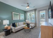 Thumbnail 5 of 38 - a living room with a couch and a ceiling fan