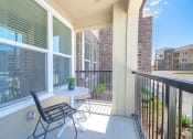 Thumbnail 16 of 38 - a balcony with a table and chairs and a large window