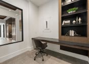 Thumbnail 27 of 38 - a desk in a room with a mirror and a chair