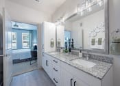 Thumbnail 13 of 38 - a bathroom with white cabinets and granite counter tops