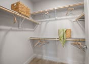 Thumbnail 15 of 38 - a walk in closet with hangers and a basket