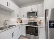 Thumbnail 2 of 38 - a kitchen with stainless steel appliances and white cabinets
