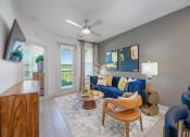 Thumbnail 10 of 38 - a living room with a blue couch and a ceiling fan