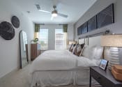 Thumbnail 9 of 35 - a bedroom with a large bed and a ceiling fan