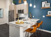 Thumbnail 4 of 41 - A kitchen with a white countertop and orange chairs.