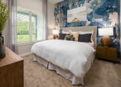 Thumbnail 16 of 41 - a bedroom with a bed and a blue and white wallpaper