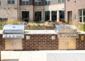 Thumbnail 37 of 41 - two stainless steel barbecue grills in front of a brick wall