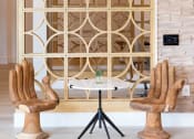 Thumbnail 30 of 41 - A wooden chair with a unique design is placed in front of a wooden lattice screen.