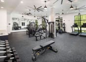 Thumbnail 26 of 41 - a gym with weights and cardio equipment in a building with windows