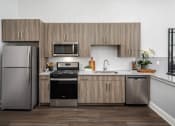 Thumbnail 1 of 41 - A modern kitchen with a refrigerator, oven, and sink.