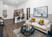 Thumbnail 10 of 41 - A modern living room with a white couch and a large abstract painting on the wall.
