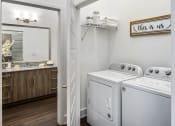 Thumbnail 22 of 41 - a white washer and dryer in a room with a mirror and a bathroom