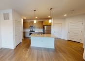 Thumbnail 8 of 41 - an empty living room with a kitchen with a counter top