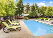 Thumbnail 9 of 44 - a swimming pool with chaise lounge chairs and trees