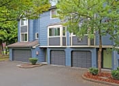 Thumbnail 17 of 28 - a blue house with two garage doors and trees