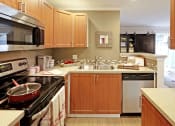 Thumbnail 5 of 28 - a large kitchen with wooden cabinets and a sink