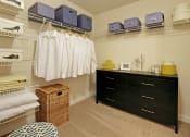 Thumbnail 10 of 28 - a walk in closet with a dresser and closets with clothes