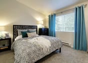 Thumbnail 25 of 30 - a bedroom with a bed and a window with blue curtains