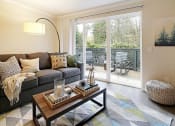 Thumbnail 19 of 30 - a living room with a couch and a coffee table and a sliding glass door