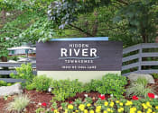 Thumbnail 2 of 30 - a sign for hidden river townhomes in front of plants and flowers
