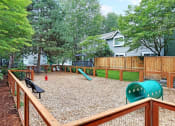 Thumbnail 10 of 30 - a fenced in play area with a playground and a swing set