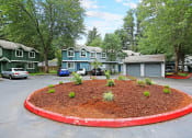 Thumbnail 4 of 30 - a circle of landscaping in a parking lot in front of houses