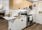 Thumbnail 4 of 27 - a kitchen with white cabinets and a stove and a fireplace