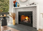 Thumbnail 6 of 27 - the fireplace in the living room is decorated with black and white tiles