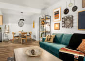Thumbnail 11 of 27 - a living room with a green couch and a dining room table