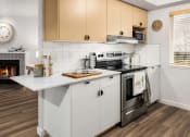 Thumbnail 8 of 27 - a kitchen with white cabinets and a stove and a fireplace