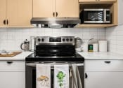 Thumbnail 13 of 27 - a kitchen with a stove and a microwave